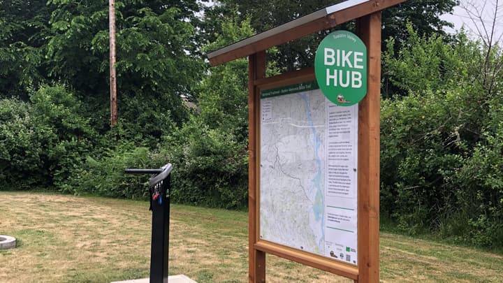 A kiosk, bearing a trail map and a sign displaying the words 'Bike Hub'.