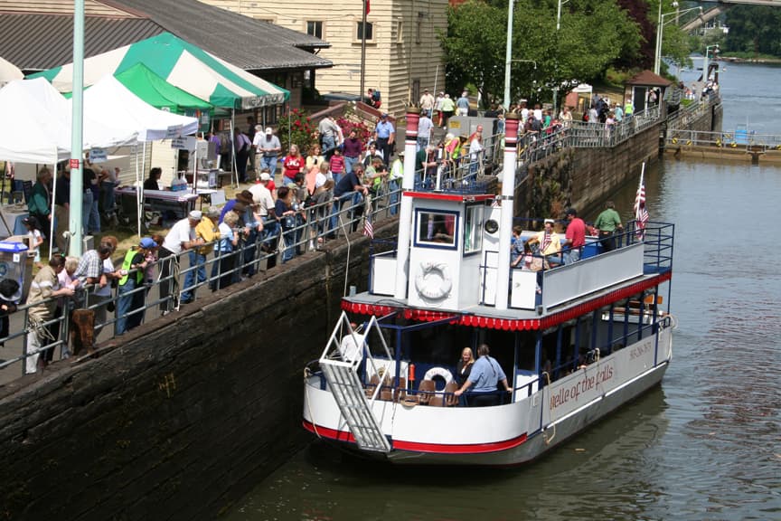 Tourists viewing a small passenger ferry as it passes.