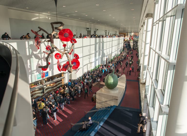 Atendees line the walls of the lobby area inside the Oregon Convention Center.