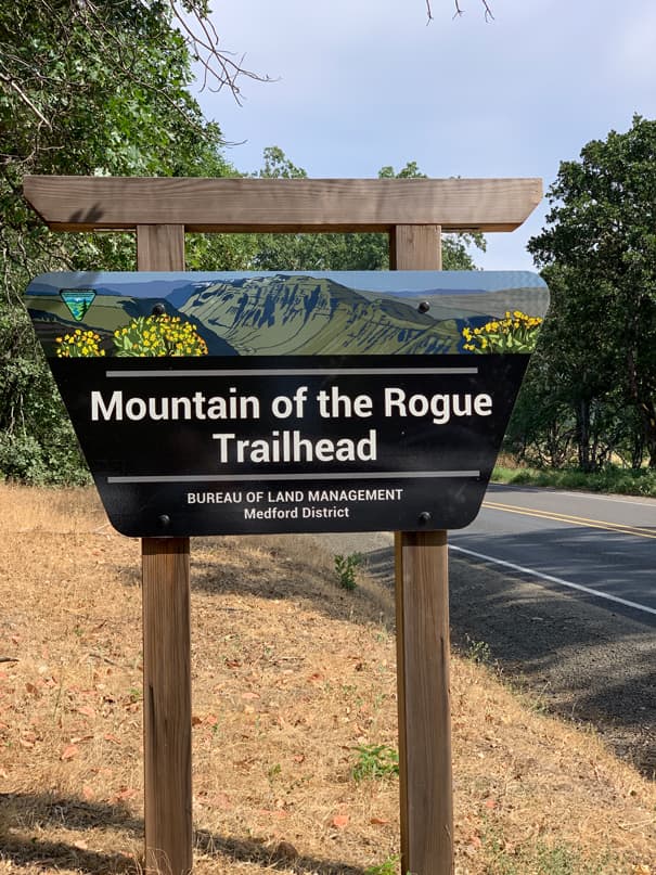 Signage indicating the beginning of the 'Mountain of the Rogue Trailhead'.